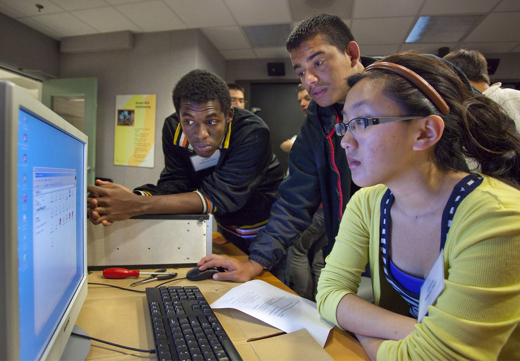 An image of three students working at a school computer.